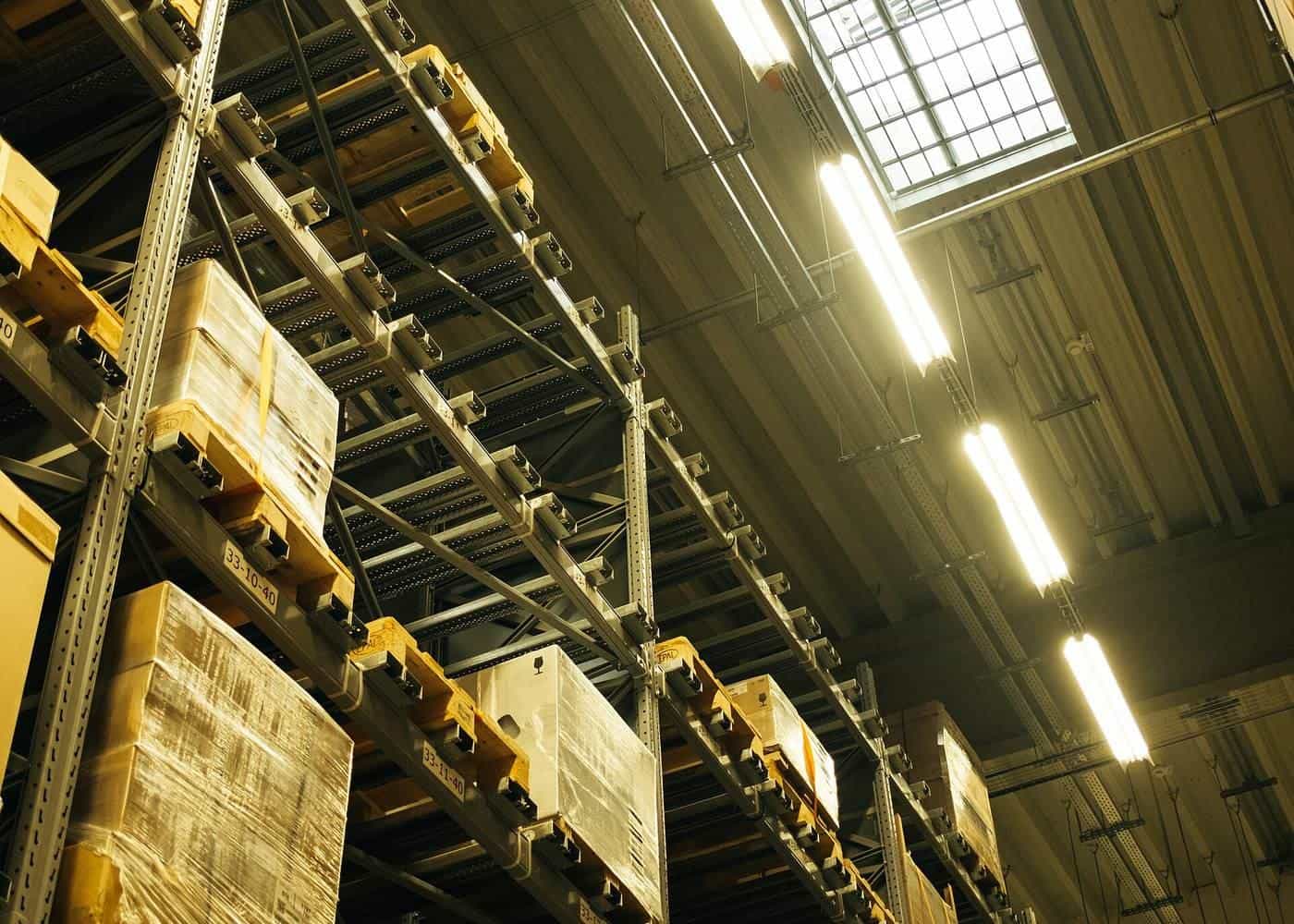 Tall warehouse shelving stacked with neatly labelled boxes and packages